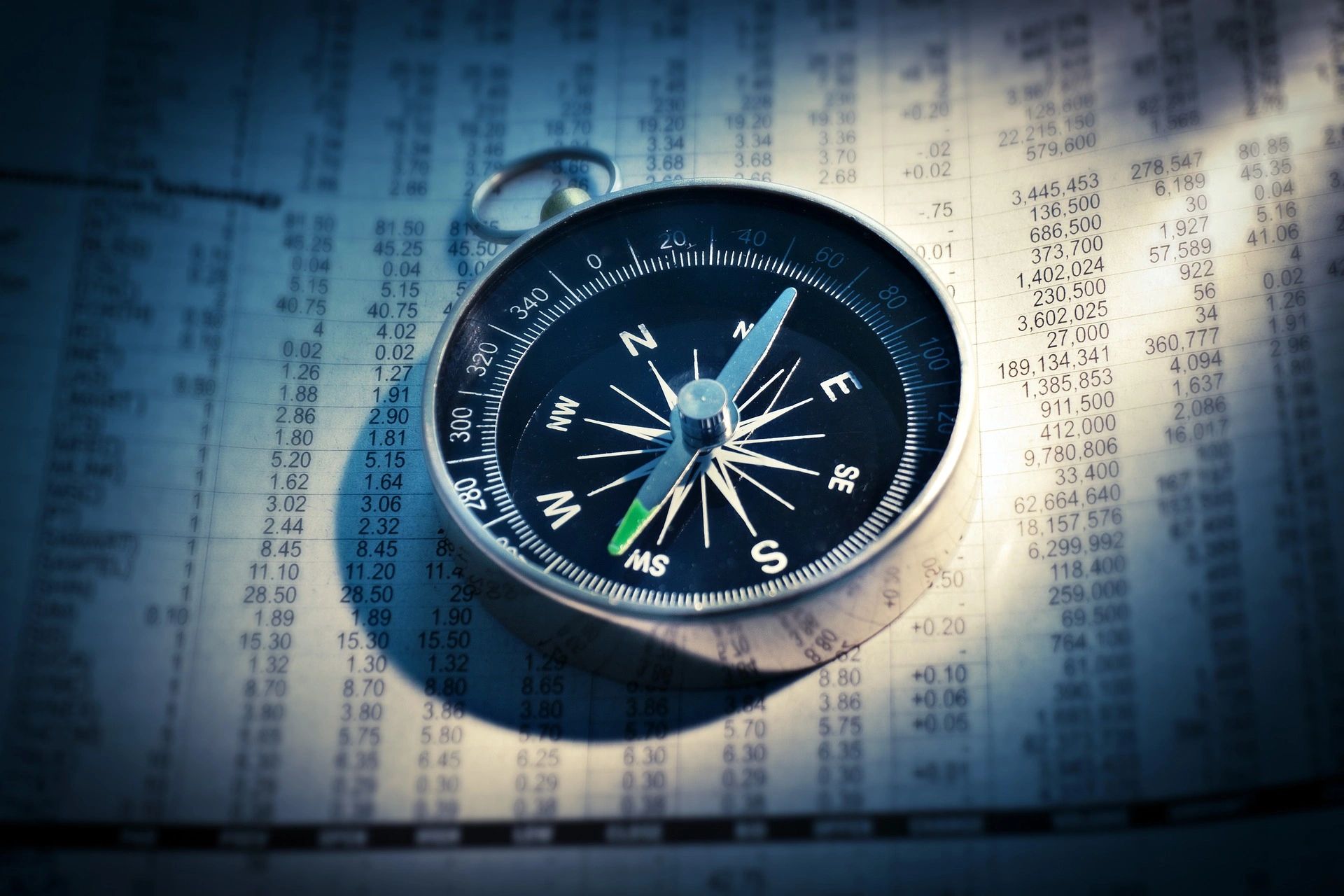 Compass resting on a financial newspaper