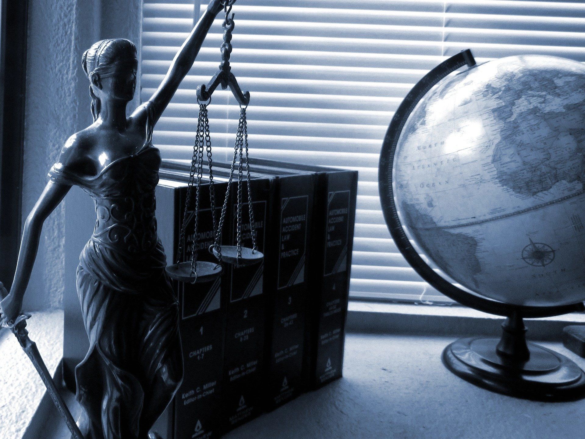 Statue of Lady Justice beside a globe