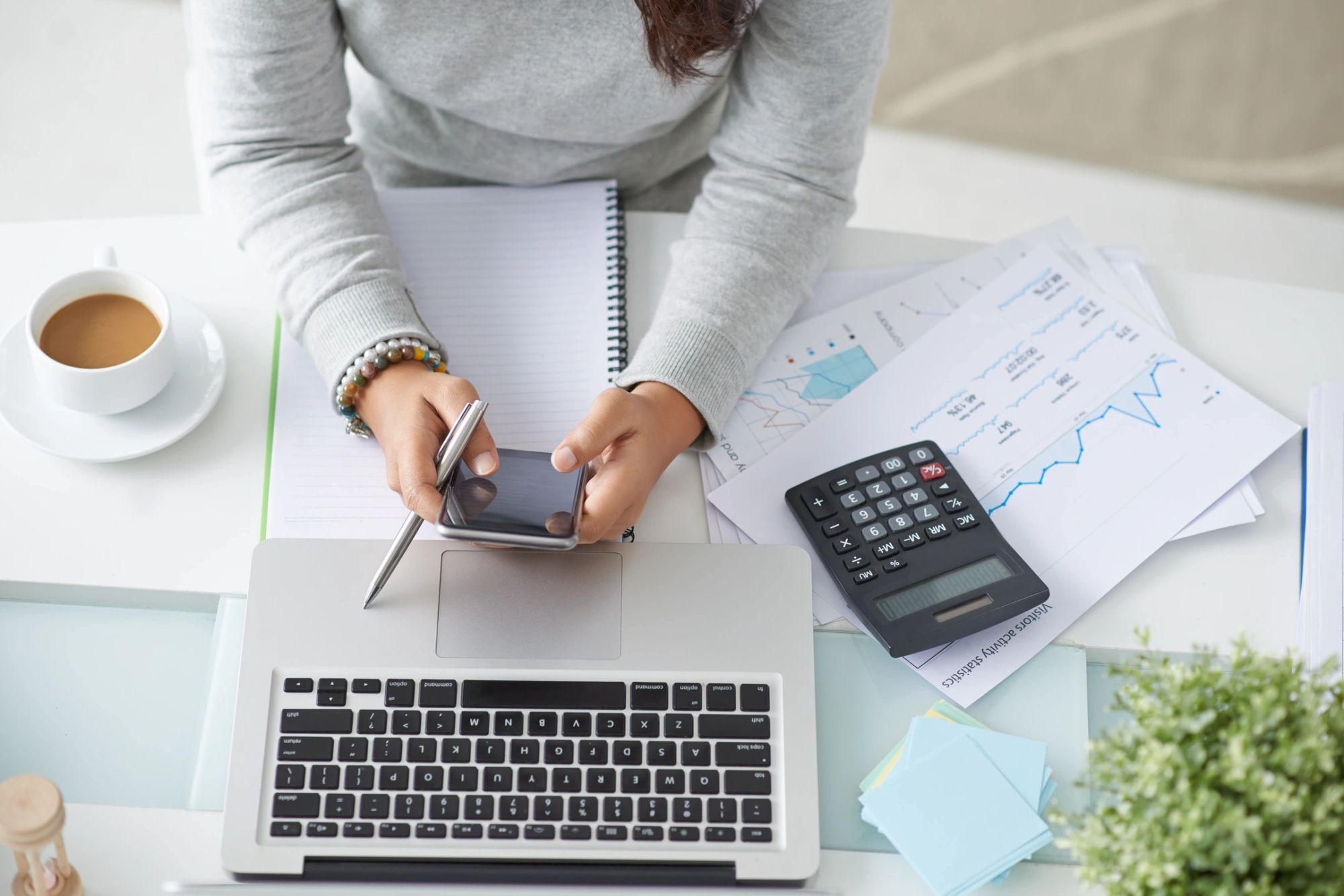 Person reviewing paperwork with a calculator