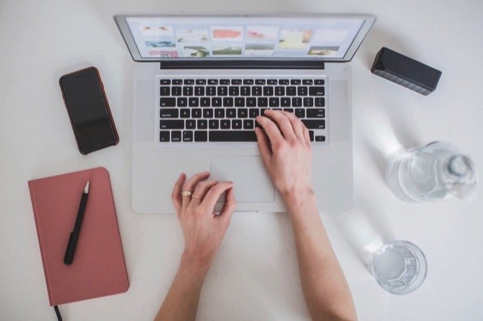Hands working on a laptop at a desk
