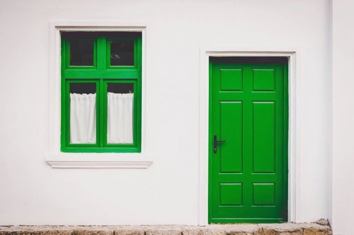 The facade of a home with a green door