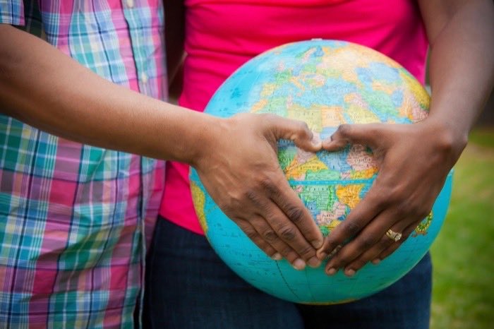 Hands cradling a small globe